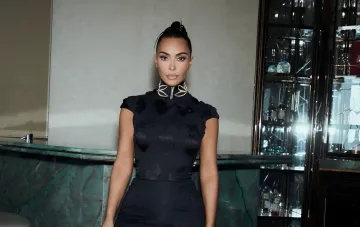 Kim Kardashian in a black mini-dress by a bar counter during a family trip to China