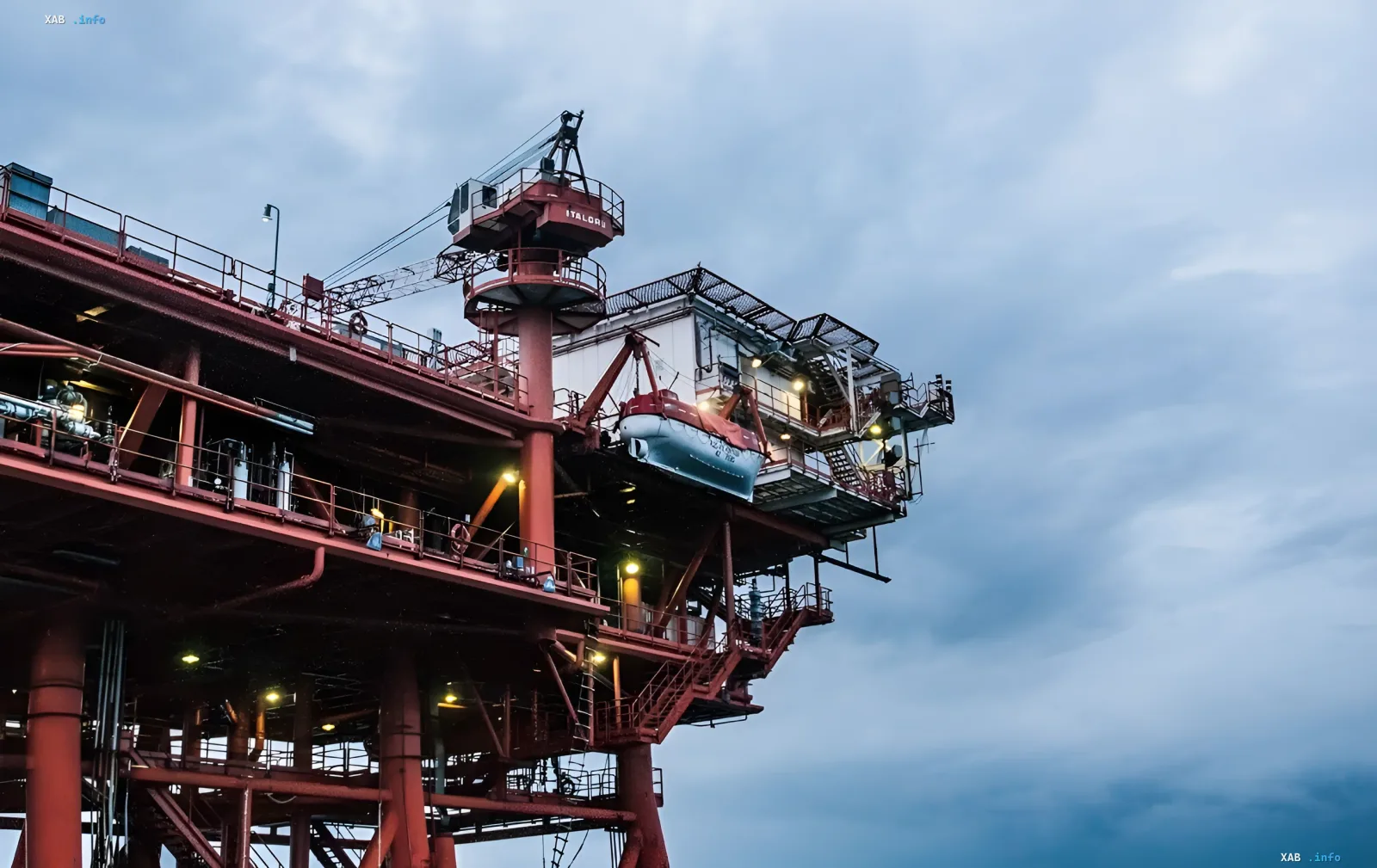 Промышленная морская газовая платформа под пасмурным небом с подъемным краном и спасательной шлюпкой