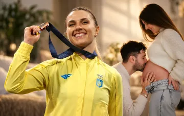 Ukrainian fencer Olga Kharlan holding an Olympic medal against the background of her fiancé Luigi Samele tenderly kissing a pregnant belly