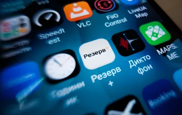 Смартфон з відкритим українським додатком Резерв+ та іншими іконками на екрані крупним планом