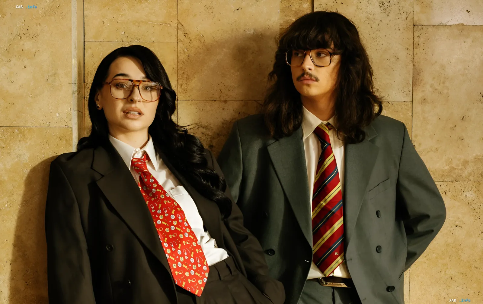 Musicians SadSvit and FIINKA in formal suits and retro glasses against a stone wall