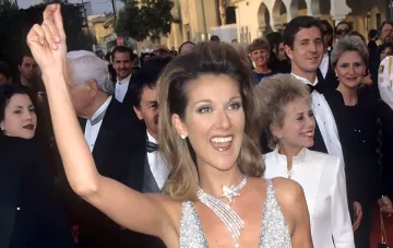 Canadian singer Celine Dion in a glamorous silver dress with a deep neckline and jewelry on the red carpet