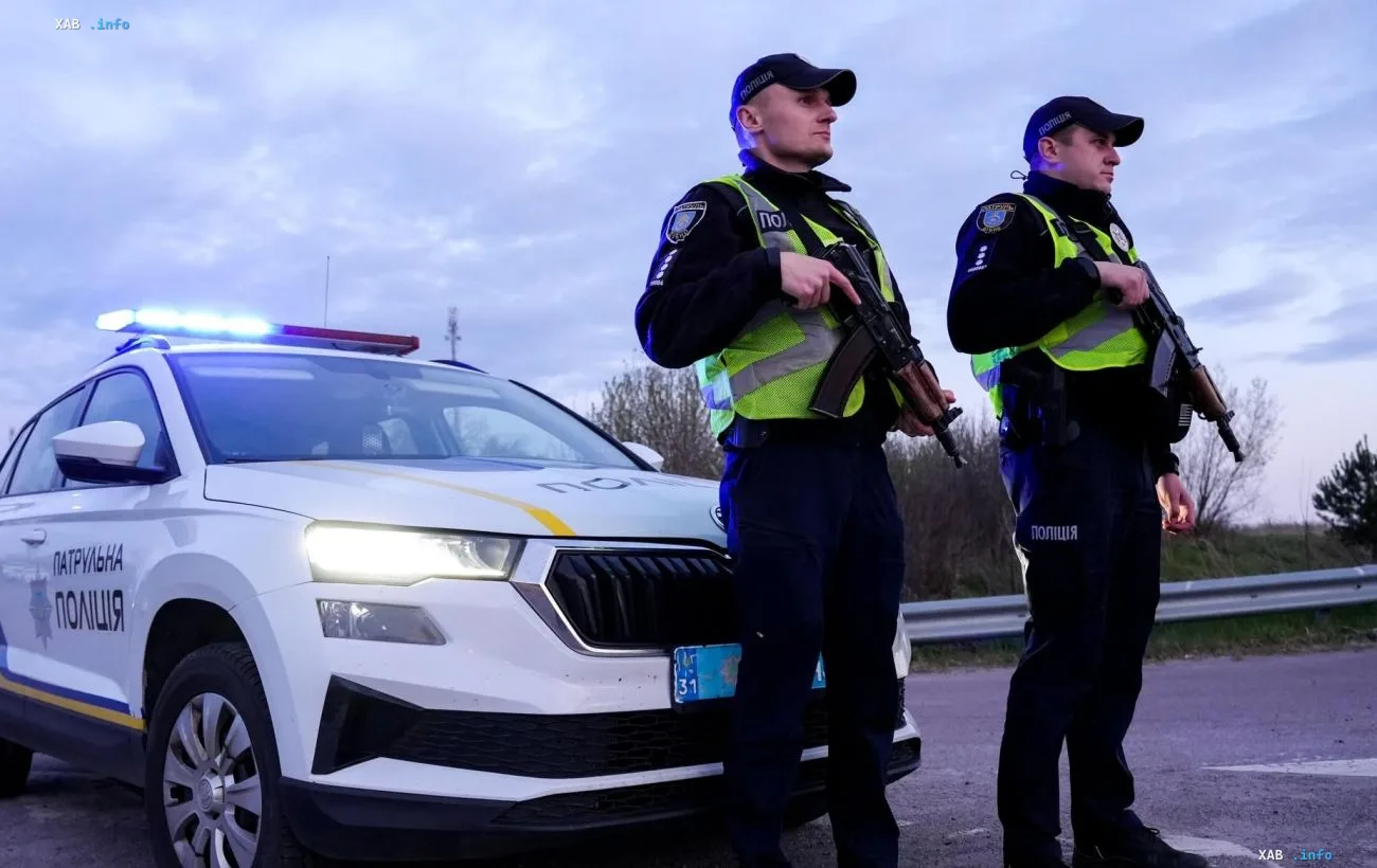 Ukrainian patrol police officers in uniform with a patrol car on the road