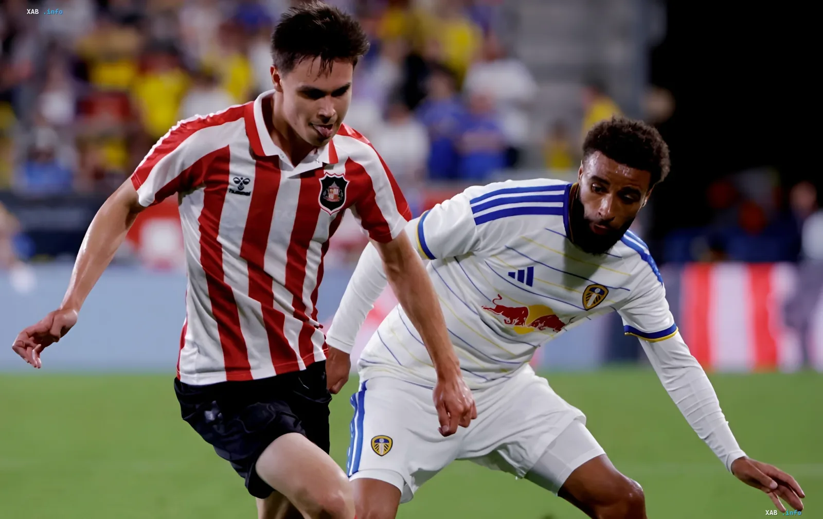Two football players in different kits battling for the ball during a Europa League match
