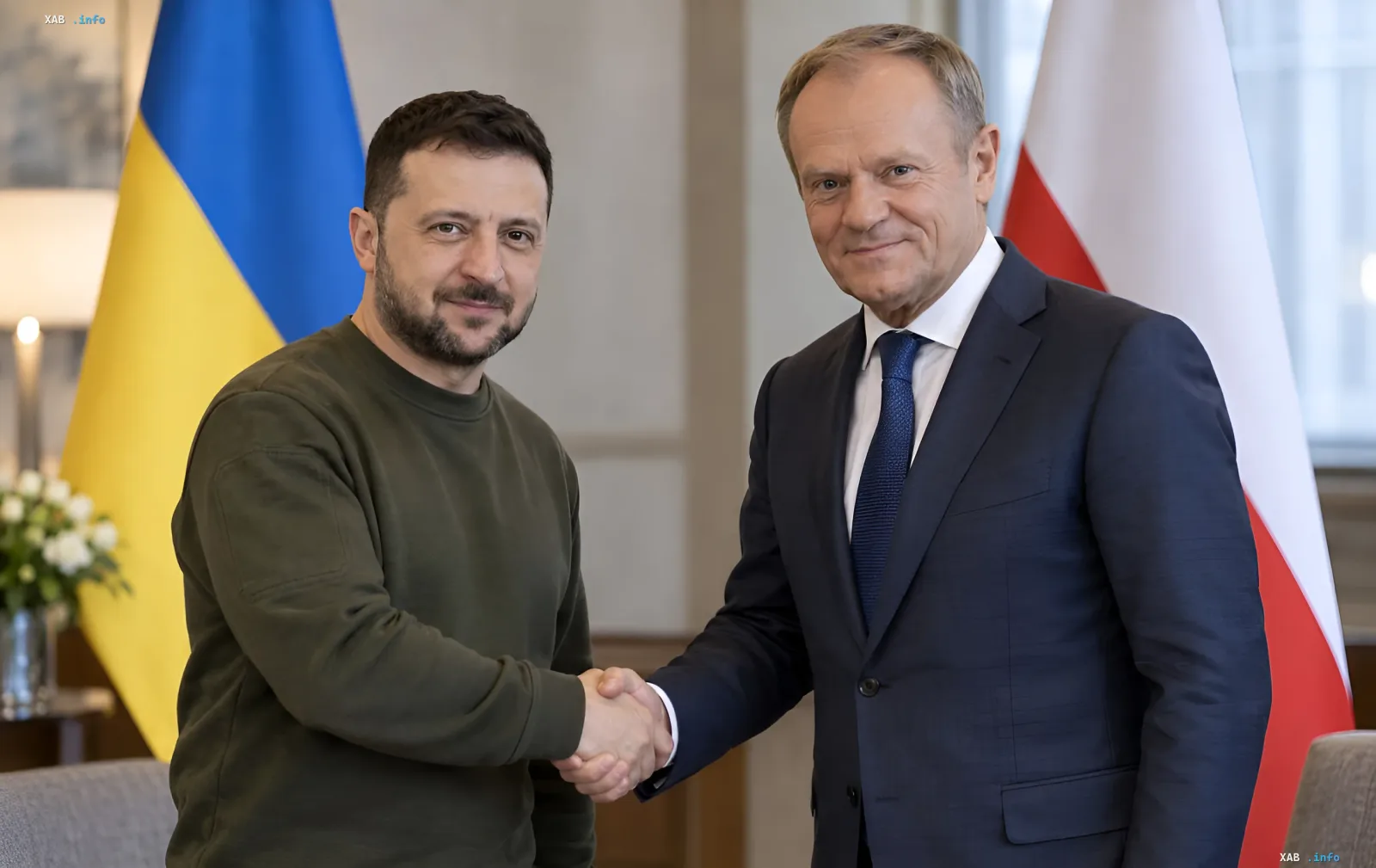 Владимир Зеленский и Дональд Туск жмут друг другу руки на фоне флагов Украины и Польши