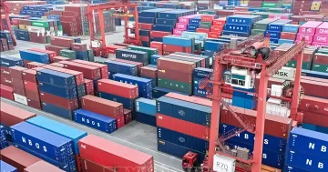 Красочные морские контейнеры и подъемный кран в большом контейнерном терминале порта