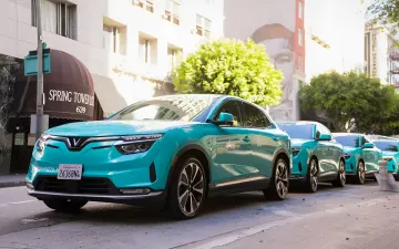 Бирюзовые электрические кроссоверы VinFast Green SM припаркованы на городской улице в Лос-Анджелесе