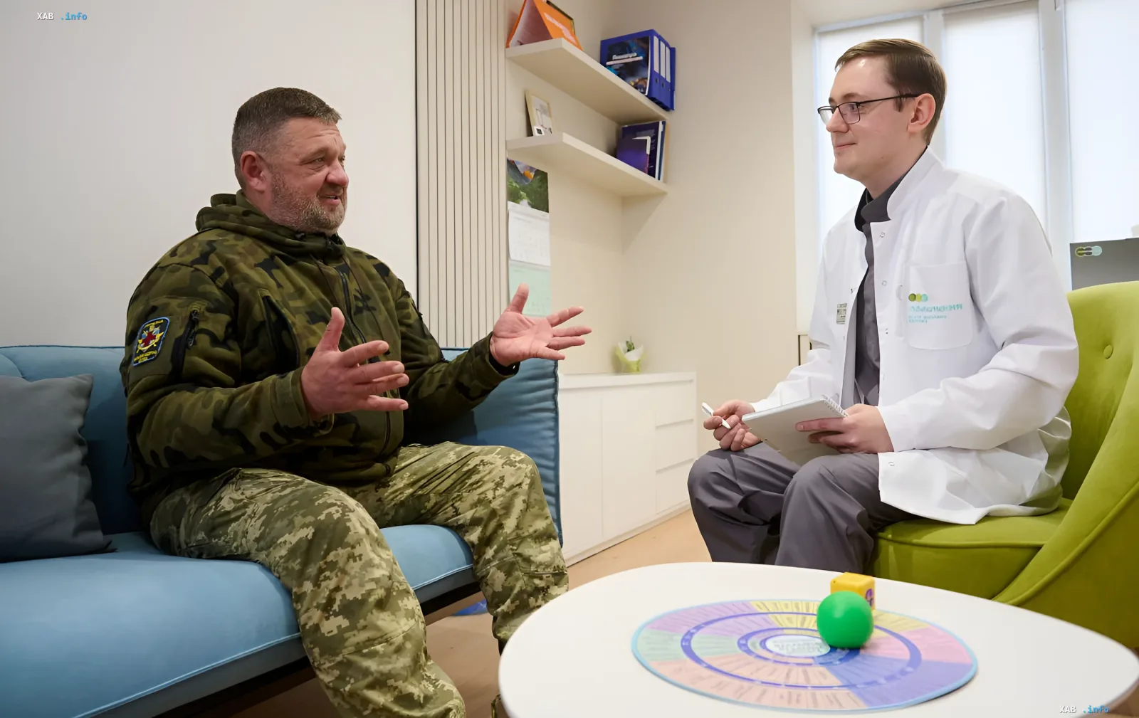 A military serviceman in camouflage communicates with a doctor in a bright consultation room of a support center