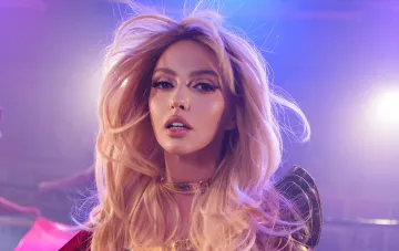 Olya Polyakova in einem lebendigen Bühnen-Look mit wehendem Haar für das Musikvideo My Future Ex