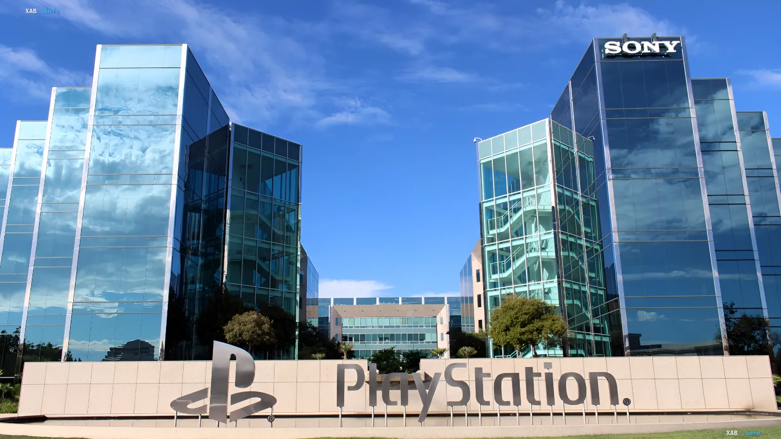 Главный офис Sony и логотип PlayStation на фоне голубого неба с облаками