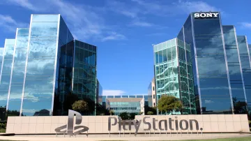 Главный офис Sony и логотип PlayStation на фоне голубого неба с облаками