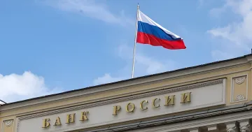 Building of the Bank of Russia with a flying Russian flag under a blue sky