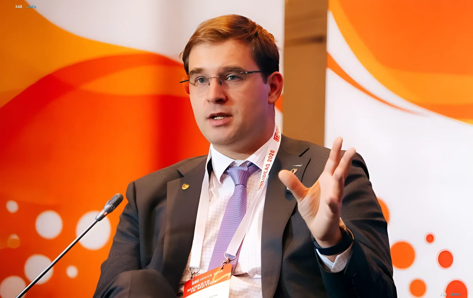 Timur Turlov speaking at a conference, gesturing during a discussion about the future of chess.