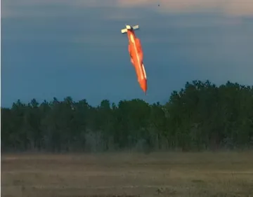 Бомба GBU-43/B MOAB в полете над лесистой местностью во время испытаний