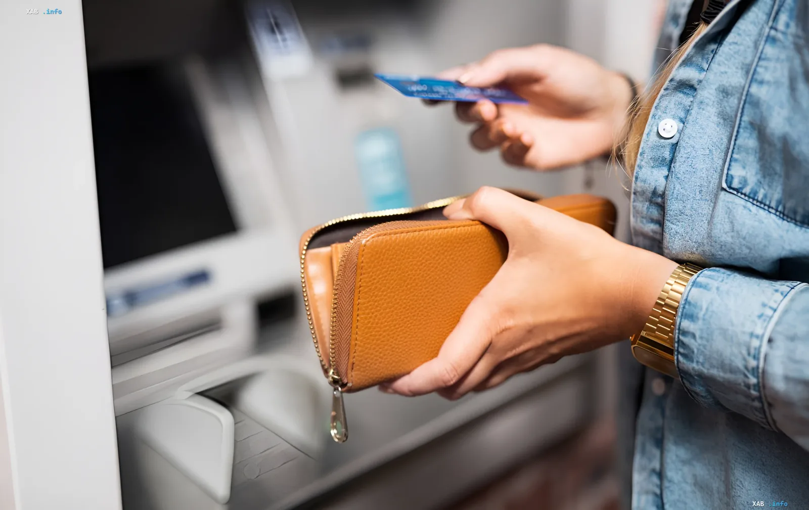 A woman holding a wallet and a plastic card in front of an ATM, illustrating financial services and the banking system