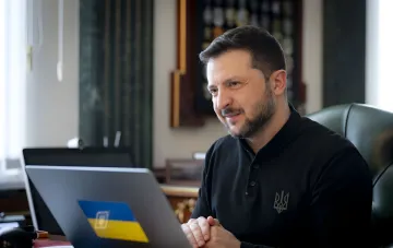Президент Украины Владимир Зеленский за рабочим столом с ноутбуком во время онлайн-брифинга