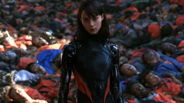 A woman in a futuristic black and red cyborg suit stands against a backdrop of hundreds of fallen people in uniform.