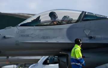Pilot im Cockpit eines F-16-Kampfjets auf der Start- und Landebahn eines Flugplatzes
