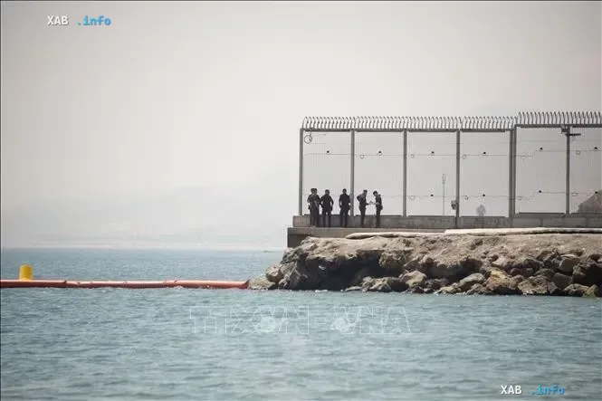 Border fence on the sea coast and security personnel against the background of the sea