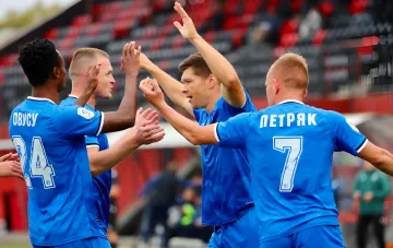 Футболісти в синій формі святкують забитий гол на стадіоні