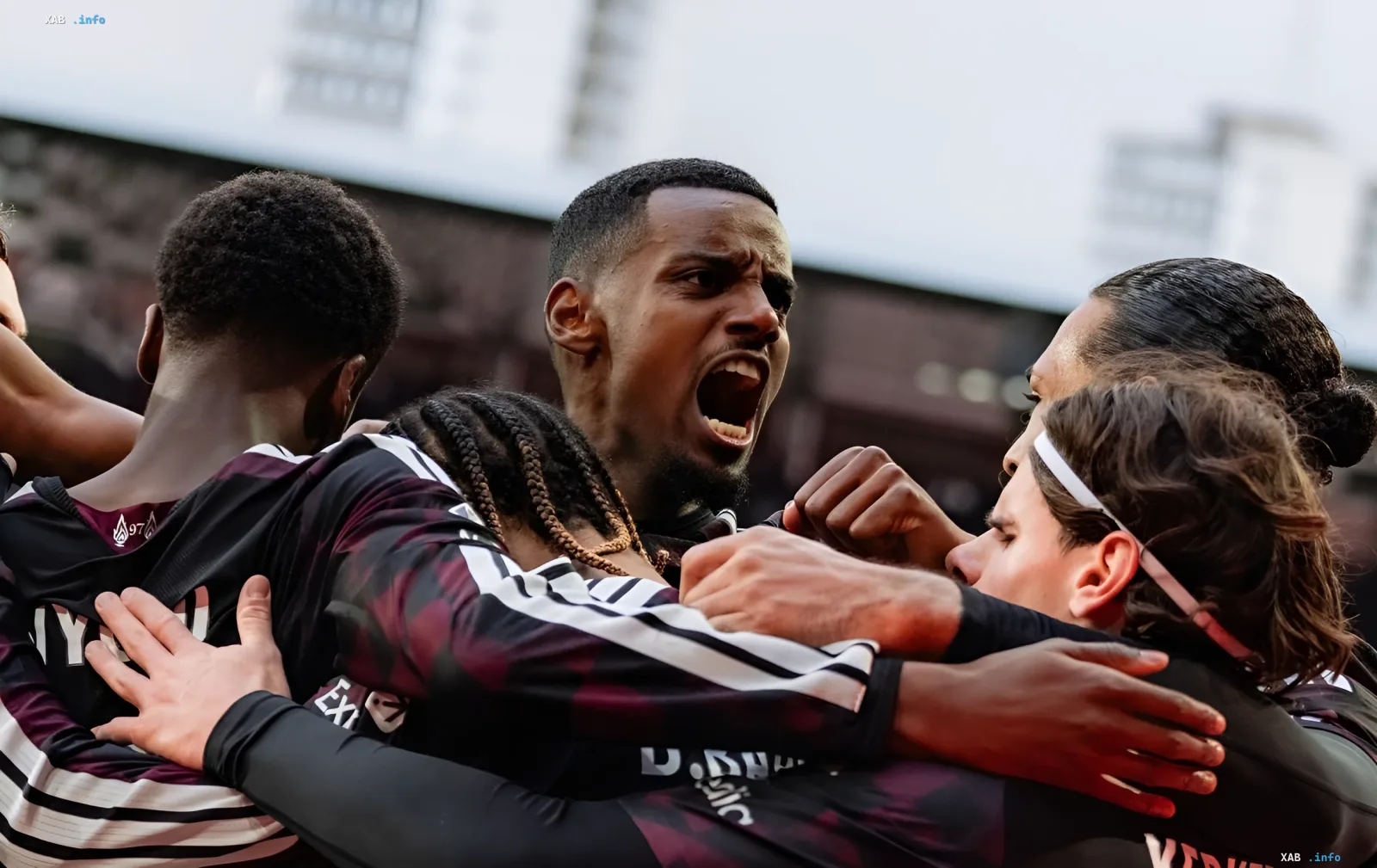 Emotional goal celebration by Brentford players in black kits shouting and embracing