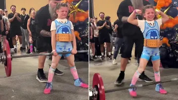 Nine-year-old female weightlifter lifting a barbell at a competition