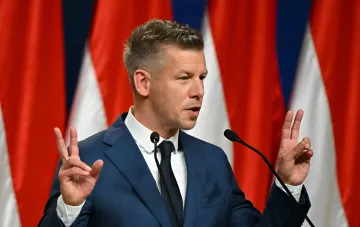 Премьер-министр Венгрии Петер Мадьяр жестикулирует во время выступления на фоне флагов