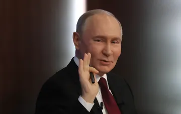 Владимир Путин выступает с речью, жестикулируя рукой на пресс-конференции