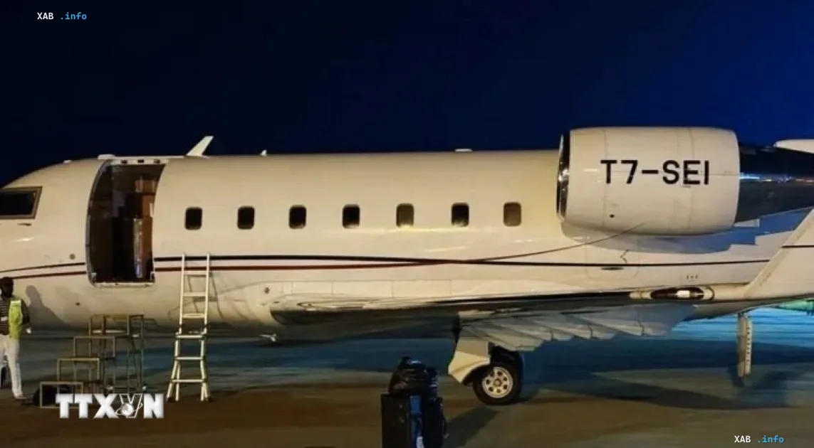 Weißes Privatflugzeug von Triton Aviation nachts auf dem Rollfeld eines Flughafens