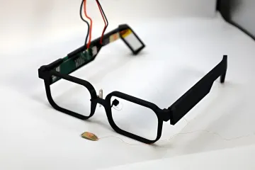 Прототип умных очков GlassTENG без аккумулятора с электронными датчиками и проводкой на белом фоне
