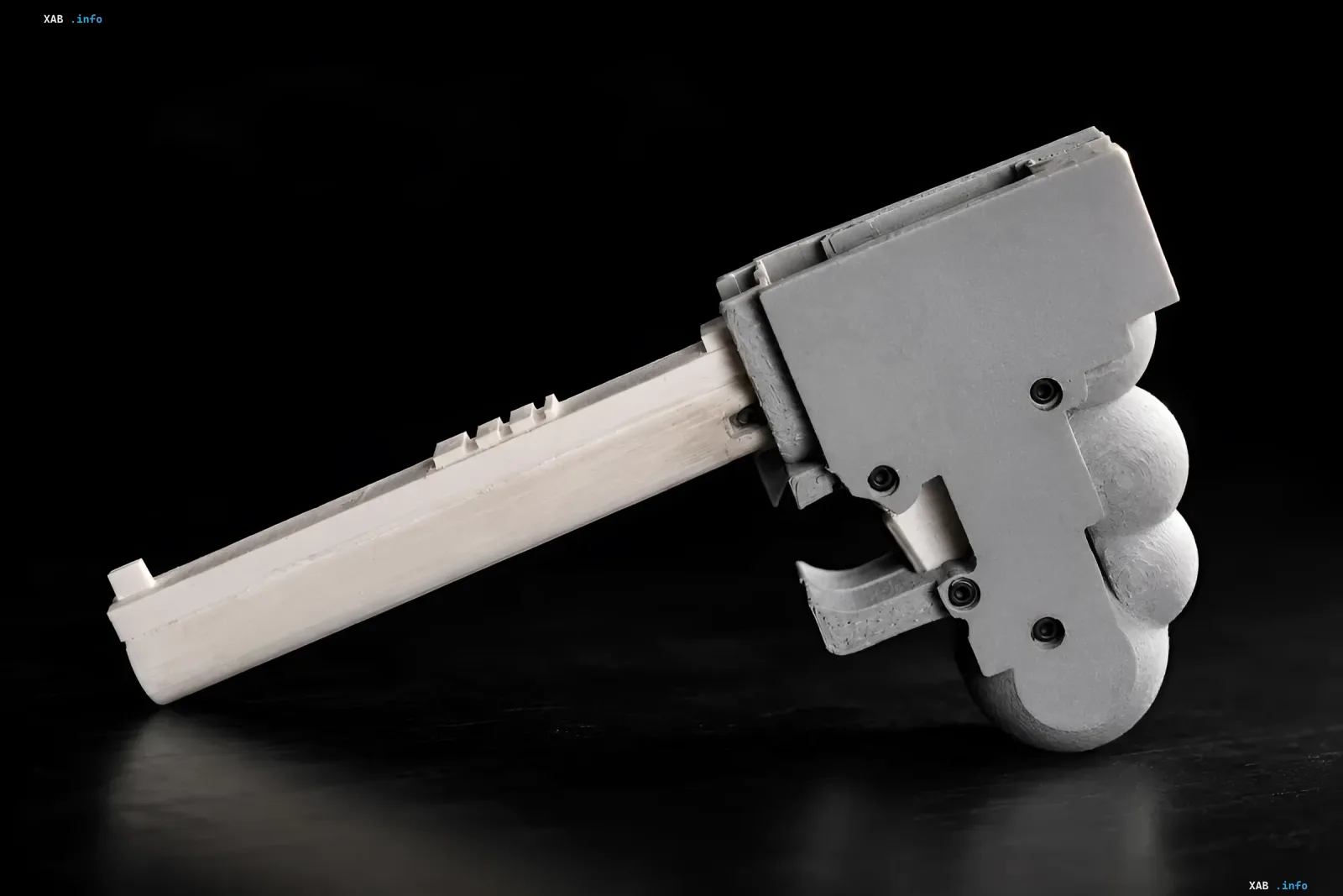 Homemade 3D-printed WASP pistol in gray with a plastic frame and metal parts on a black background