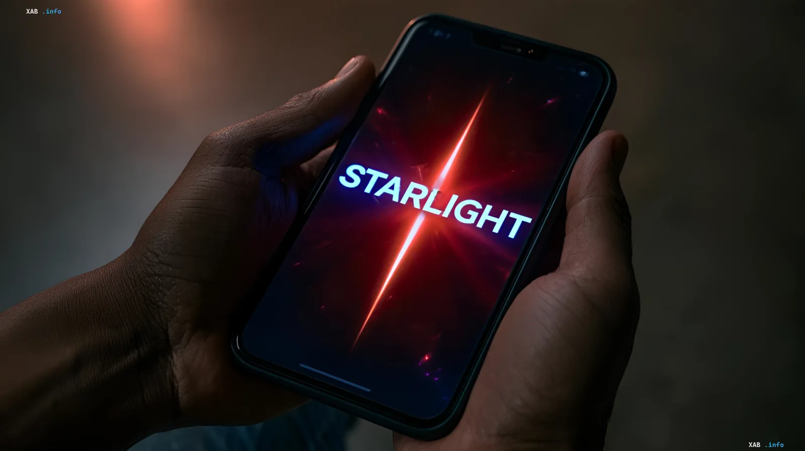 Person holding a smartphone displaying the word Starlight on a glowing red screen in the dark