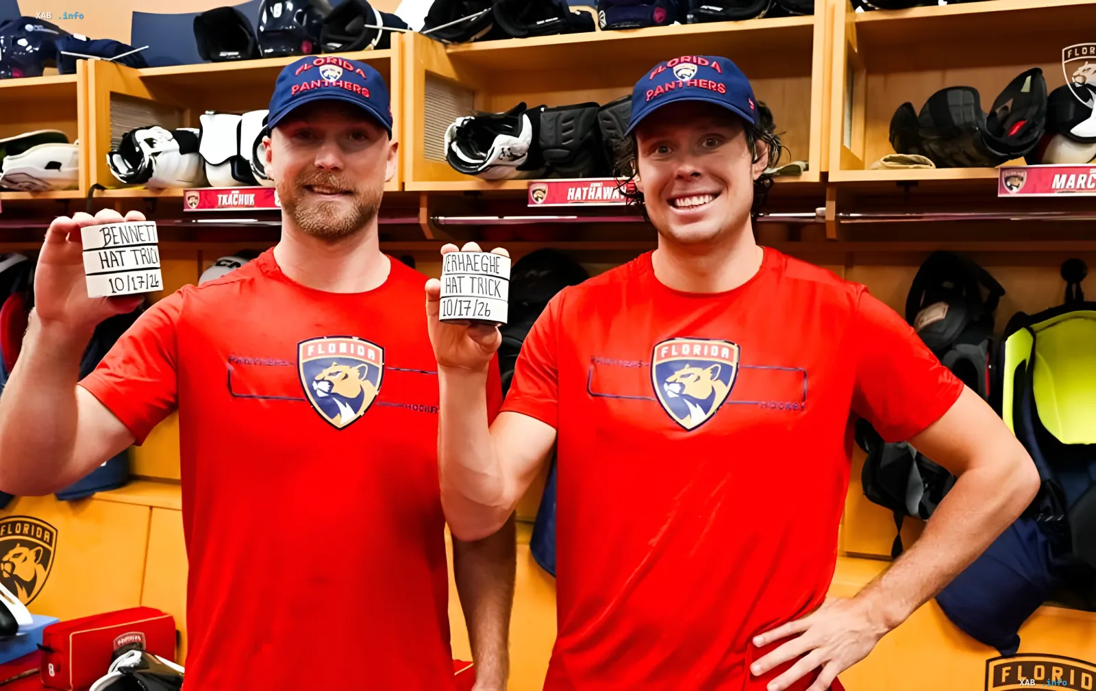 Florida Panthers hockey players holding hat-trick boards in the locker room