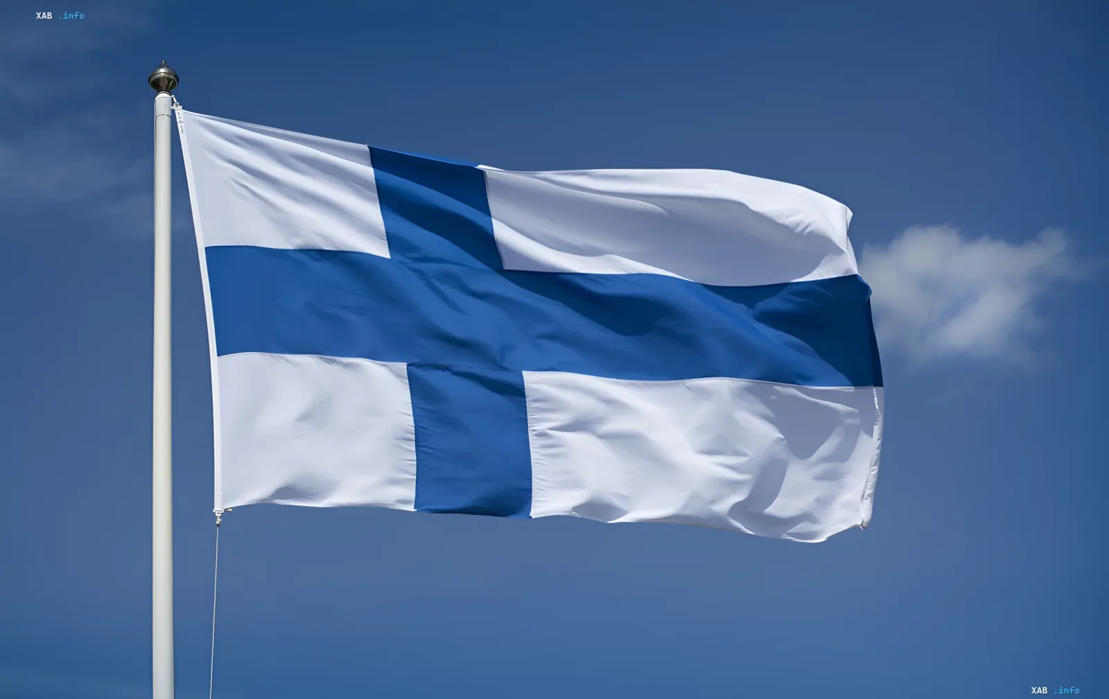 Die Flagge Finnlands weht an einem weißen Fahnenmast vor einem klaren blauen Himmel mit einer Wolke
