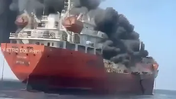 Горящий в Ормузском проливе нефтяной супертанкер с густым черным дымом