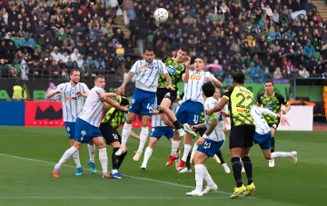 Fussballspieler im Luftzweikampf während eines regnerischen UPL-Spiels