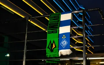 Футбольные шарфы клубов Полесье и Динамо Киев на фоне освещенного здания в ночное время