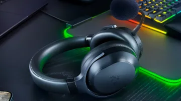 Беспроводная игровая гарнитура Razer Barracuda V2 Pro черного цвета на игровом столе с подсветкой.