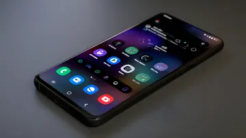 Сучасний смартфон на сірому фоні з увімкненим екраном та кольоровими іконками додатків