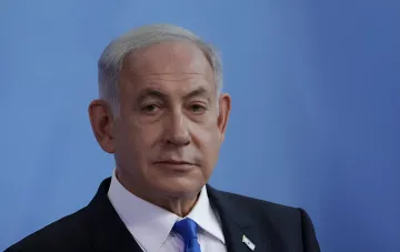 Премьер-министр Израиля Биньямин Нетаньяху выступает на брифинге перед синим фоном
