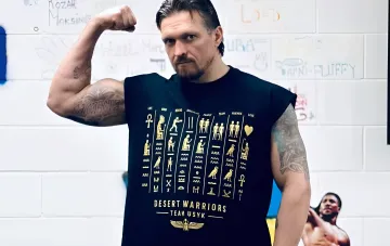 Ukrainian boxer Oleksandr Usyk flexes his bicep wearing a t-shirt with Egyptian hieroglyphs