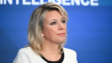 Maria Zakharova speaking at a briefing against a blue background