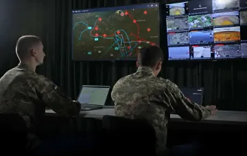Украинские военные операторы работают за компьютерами в комнате управления боевой системы DELTA