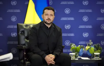 Президент Украины Владимир Зеленский во время выступления на фоне флагов Украины и ООН.