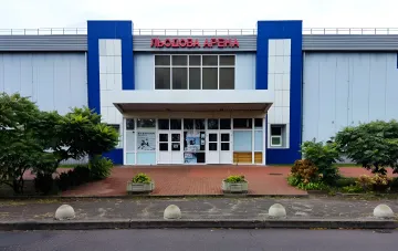 Facade of the blue and white ice arena in Kyiv with the sign ЛЬОДОВА АРЕНА before the nighttime shelling
