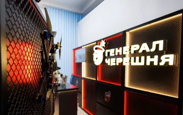 Booth of Ukrainian drone manufacturer General Chereshnya featuring UAV exhibits and a neon sign