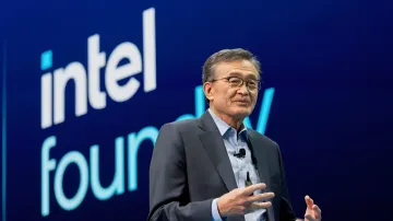 Intel CEO Lip-Bu Tan speaking at a presentation against a blue branded background