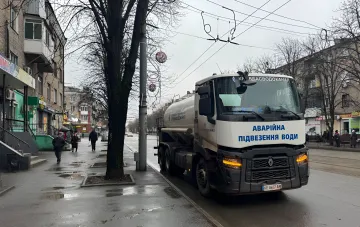 Специализированная машина аварийной подвозки воды коммунального предприятия Кременчугводоканал на мокрой городской улице.