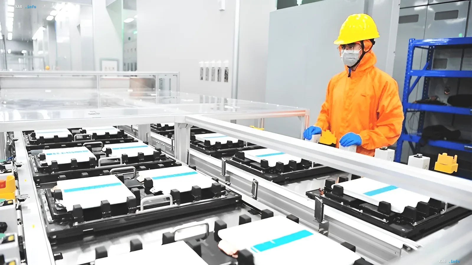 A worker in protective gear and a hard hat monitors lithium-ion battery production at a high-tech plant in China.