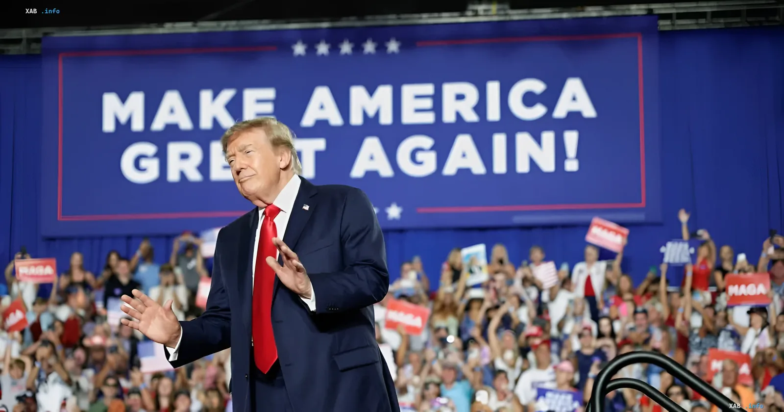 Дональд Трамп жестикулює на тлі синього банера Make America Great Again під час передвиборчого мітингу